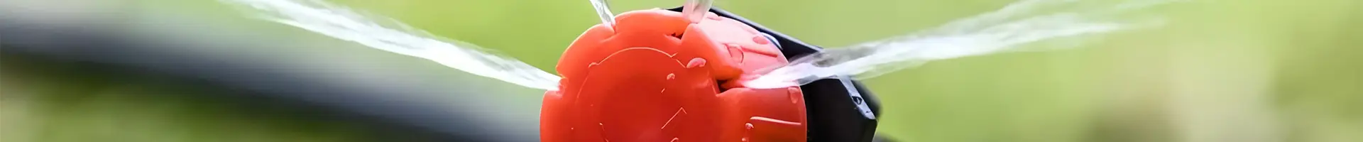 Un gocciolatore regolabile installato su un tubo sta spruzzando acqua.