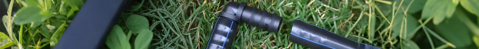 Un connettore di irrigazione collega due tubi sull'erba.