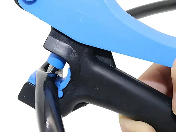 A hand is holding a hole punch to punch a pipe.